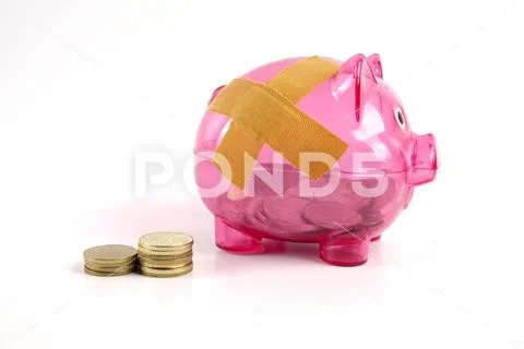 SAVING DETERIORATE CONCEPT. Red piggy bank with bandage and small stack of c Stock Photos
