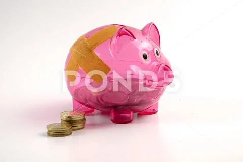 SAVING DETERIORATE CONCEPT. Red piggy bank with bandage and small stack of c Stock Photos