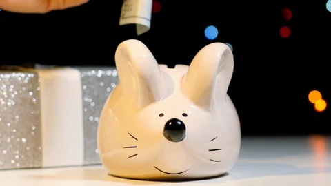 Saving dollars in a mouse bank Stock Footage 118884235