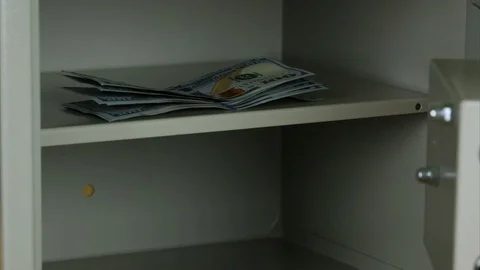 Saving dollars in the safe with the combination lock. Stop motion Video stock 86328307