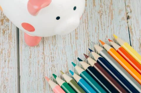 Saving for education or back to school concept, piggy bank and colorful marke Foto stock