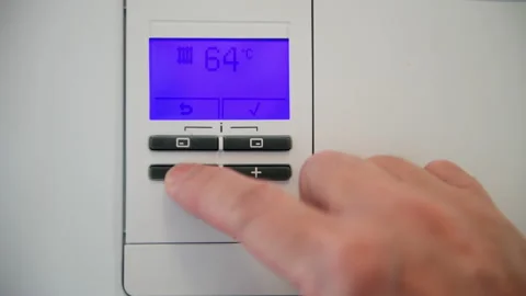 Saving energy cost by turning down the boiler temperature. Stock Footage 236466672