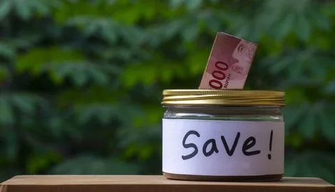 Saving Jar with Rupiah Banknote for Personal Finance Concept Stock Photos