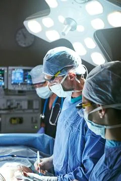 Saving lives is top priority. surgeons in an operating room. Stock Photos
