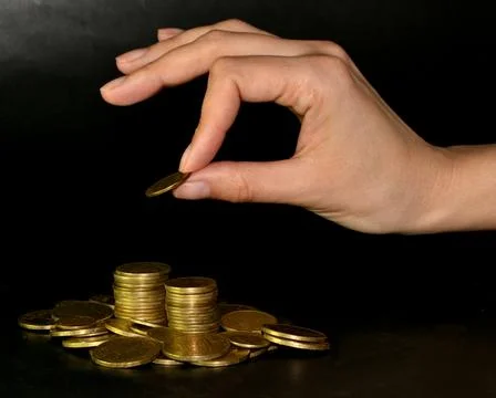 Saving money concept by adding gold coin to a pile of coins Foto stock