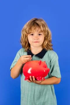 Saving money concept. Kid saving money in a piggy bank, learning about saving Stock Photos