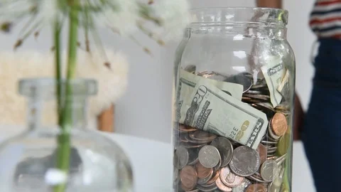 Saving money in a jar Stock Footage
