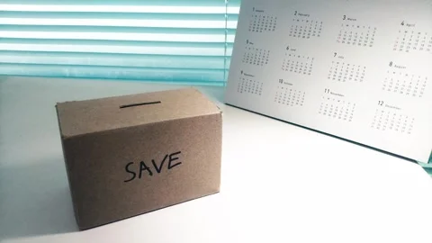 Saving money by putting coins in a box savings Stock Footage 276088376