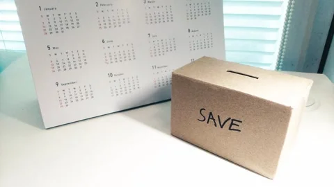 Saving money by putting coins in a box savings Stock Footage 276339172