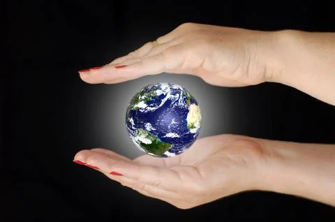 Saving the planet. Earth between two women's hands. Stock Photos