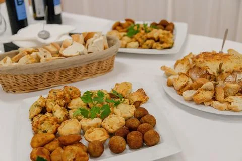 A savory assortment of appetizers, bread, mini pies, croquettes, and cheese Stock Photos