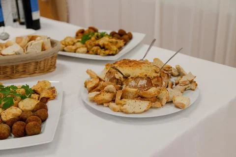 A savory assortment of appetizers, bread, mini pies, croquettes, and cheese Stock Photos
