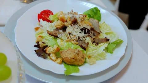 Savory caesar salad combining roasted chicken, crisp croutons, shaved parmesan 스톡 사진