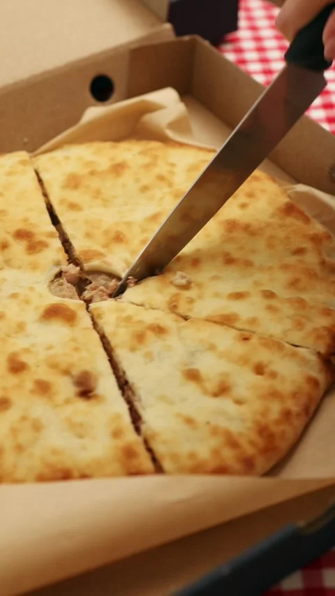 Savory cheese bread is sliced for sharing during a casual gathering Stock Footage 315552121