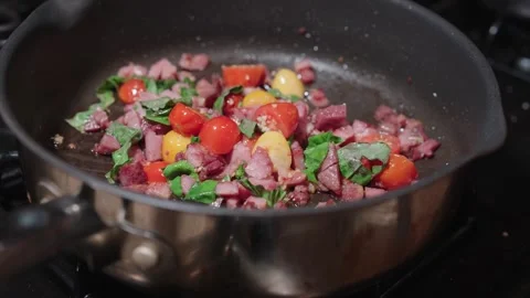 Savory ham, cherry tomatoes, and fresh basil searing in a hot skillet Stock Footage 327552516