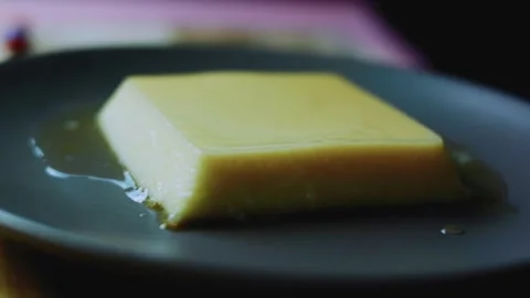 Savory ingredient study of lifting the dish to reveal a square caramel flan Stock Footage 342154072