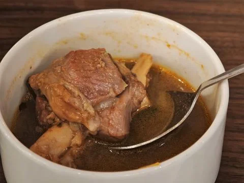 Savory mutton nalli bone soup served hot in a white bowl with a spoon rich .. Stock Photos