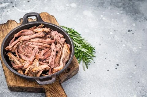 Savory pulled beef brisket served in a skillet, dipping  creating an appeal.. Stock Photos