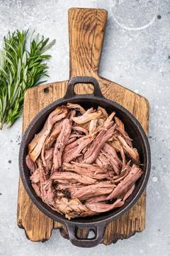 Savory pulled beef brisket served in a skillet, dipping  creating an appeal.. Stock Photos