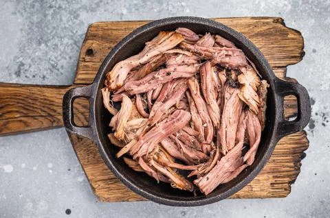 Savory pulled beef brisket served in a skillet, dipping  creating an appeal.. Stock Photos