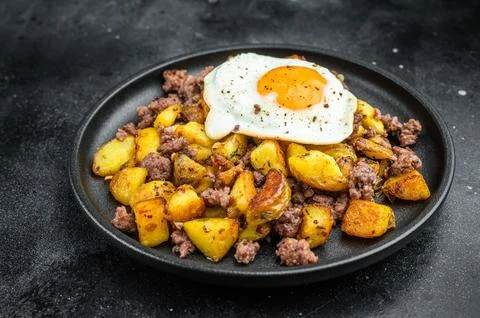 Savory skillet style hash of diced potatoes, ground beef and sunny egg on d.. Stock Photos