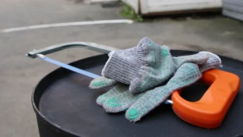 Saw and gloves lie on the barrel Stock Footage 145538341