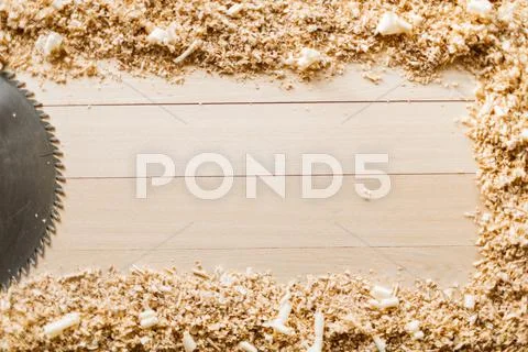 Saw-blade and sawdust on wooden background Stock Photos