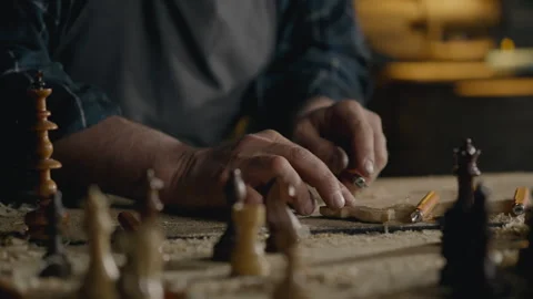 Sawing, Middle-aged builder Carefully Carving wood Making chess pieces In th Stock Footage 242539026