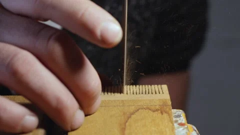 Sawing teeth for a wood comb. carpenter cuts the slots with a hand saw Stock Footage 156669944