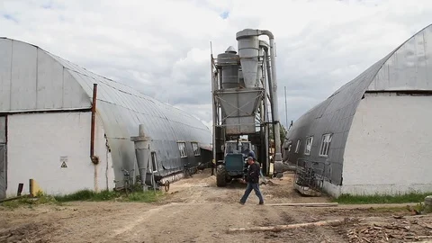 Sawmill. The man is walking in front of the tractor Stock Footage 74430397