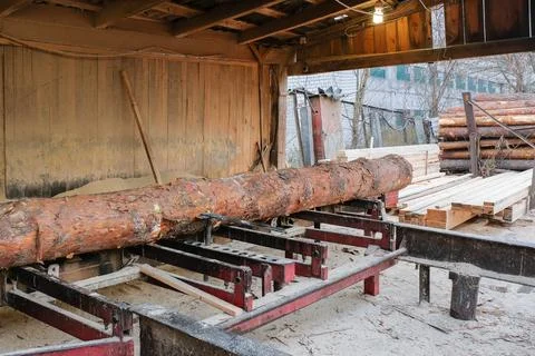 Sawmill. The process of processing wood on the old sawmill equipment. Stock Photos