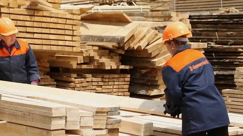 Sawmill. The workers puts the boards. Stockbeeldmateriaal 74430464