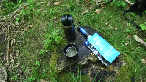 Sawyer Mini Water Filter on Tree Stump. Water Filter for Wilderness Survival Stock Footage 306537169