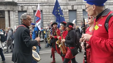 Saxaphone playing protesters marching against Brexit deal Stock Footage 118276605