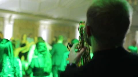 Saxophone player performing a solo on party. Saxophonist play on golden Stock Footage 196003586