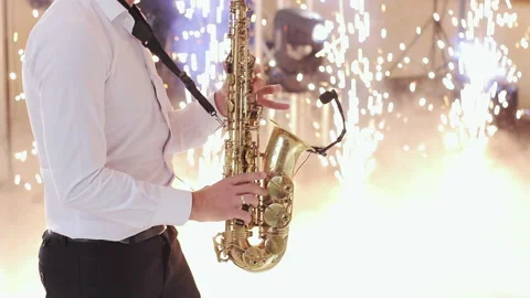 Saxophone player performing a solo on wedding party. Saxophonist play on golden Video stock 196006097