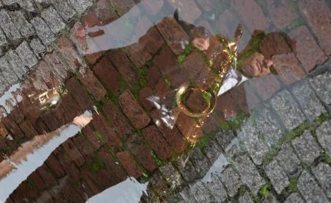 Saxophone player reflected in puddle Stock Photos
