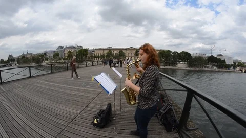 Saxophonists On A Bridge Over The Seine River in Paris Stock Footage