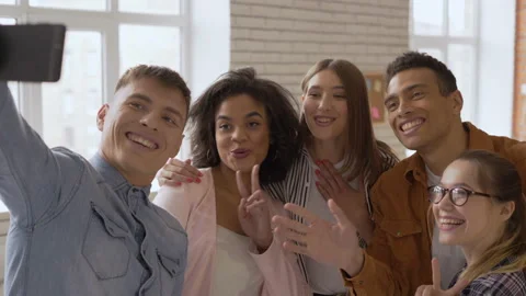 Say hello! mixed race group of 5 people. Cheerful people talking on a cell phone Stock Footage 107870397