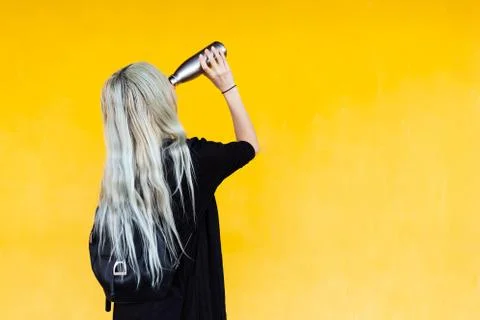 Say No to PLASTIC! Back view of young blonde girl with black backpack and bottle Stock Photos