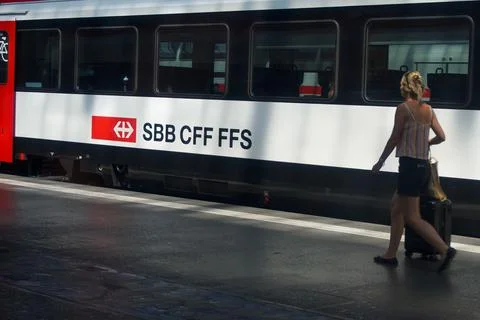 SBB CFF FFS Swiss train with passenger walking on station platform with lugga Stock Photos