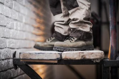 Scaffold Use in Construction Industry Concept Photo. Men Staying on Wood Plan Photos