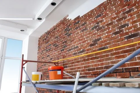 Scaffolding and equipment near brick wall with tile leveling system in repa.. Stock Photos