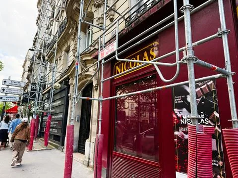 Scaffolding and red Nicolas storefront on a Paris France street during buil.. Foto stock