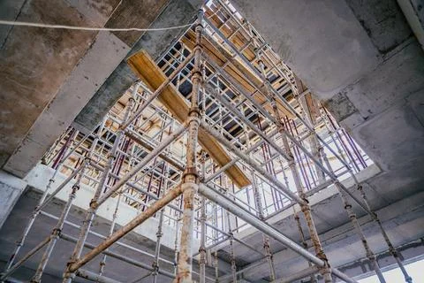 Scaffolding on a construction site is assembled in a staircase for the movement Stock Photos