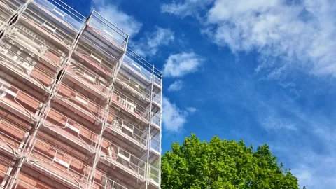 Scaffolding Covers Building with Leafy Trees and Blue Sky in Paris Urban Setting Stock Footage 335984032