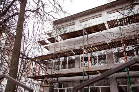 A scaffolding in front of a building, building reconstruction. Stock Photos