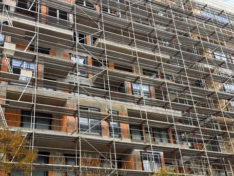 Scaffolding pattern on the facade of an urban construction site. Engineering  Stock Photos