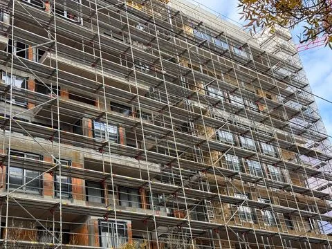 Scaffolding pattern on the facade of an urban construction site. Engineering  Stock Photos