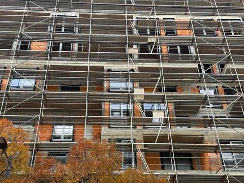 Scaffolding pattern on the facade of an urban construction site. Engineering  Stock Photos